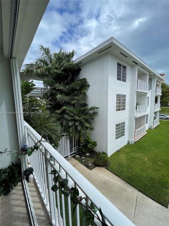 View from a balcony overlooking a multi-story building with a flat roof.