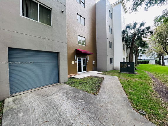 Front view of a multi-story building with garage door and entrance.