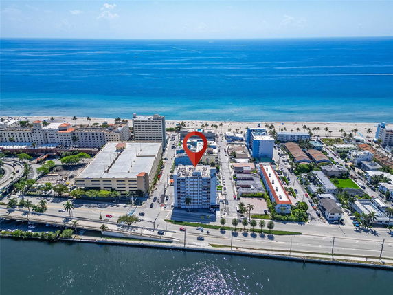 Wide-angle view of a coastal city with multiple buildings facing the ocean.