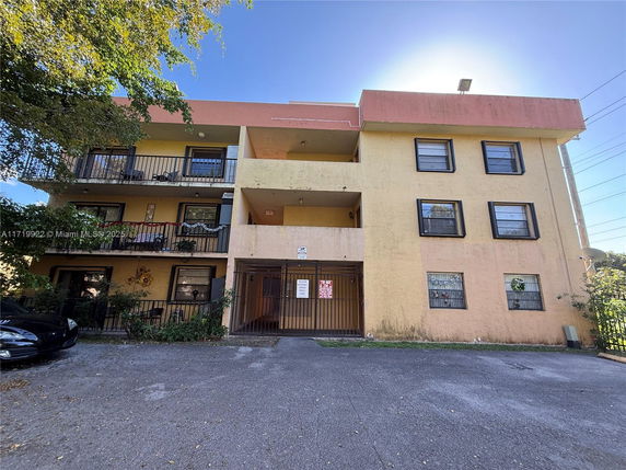 Front view of a three-story apartment building with balconies.