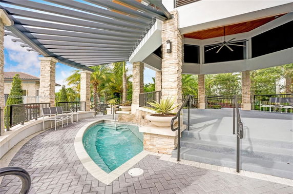 Outdoor area with a small swimming pool and pergola structure.