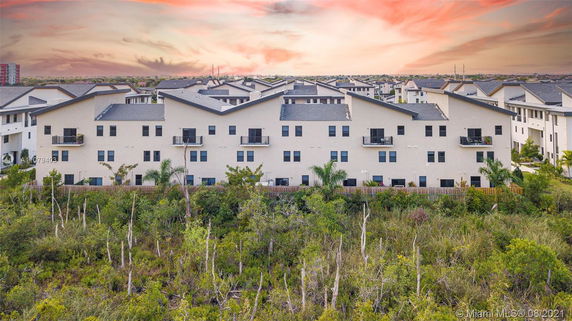 Rear view of a large residential building with multiple balconies.