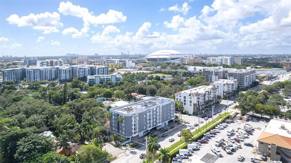 Aerial view of a cityscape with multiple mid-rise buildings and lush greenery.