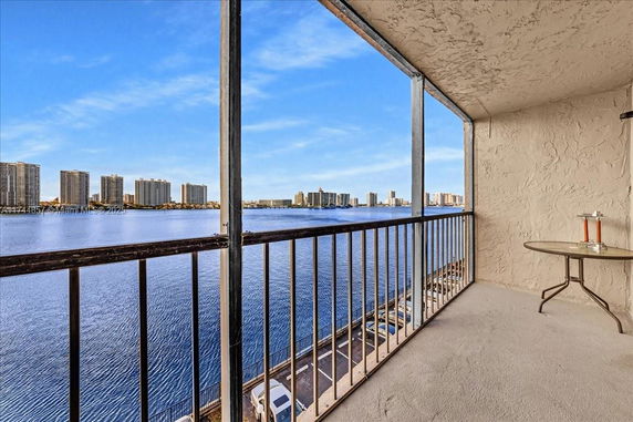 Panoramic view from a balcony overlooking water and distant buildings.