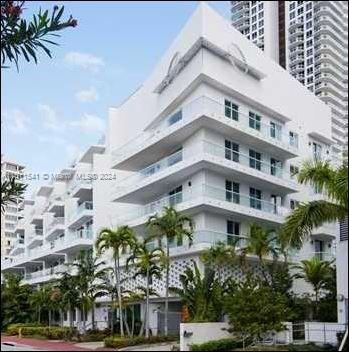 Front view of a modern multi-story building with balconies.