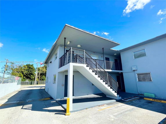 Front view of a two-story building with an external staircase.
