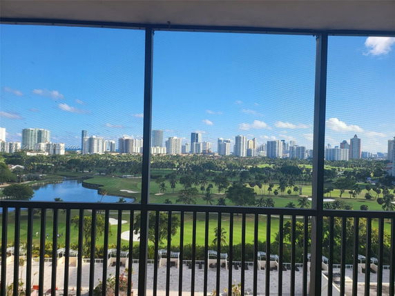 Panoramic view of cityscape with lush green landscape and water body.