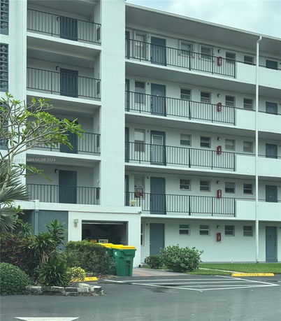 Front view of a multi-story apartment building with balconies.