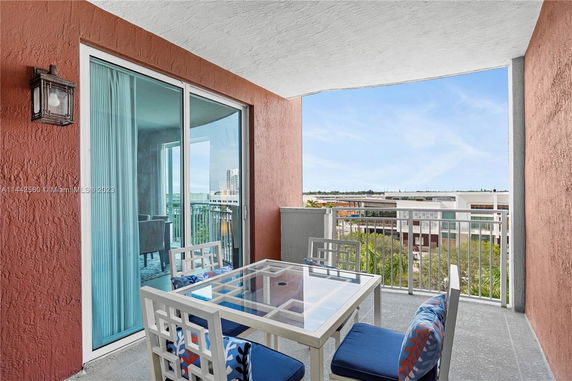 Balcony with outdoor seating and view of surrounding buildings.