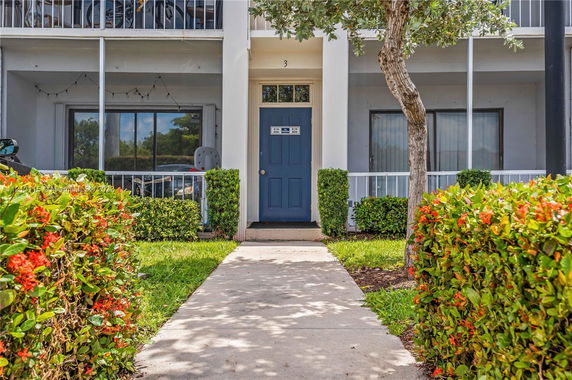 Front view of a two-story building with a blue door and balconies.