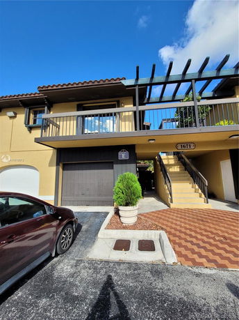 Front view of a two-story house with a garage and outdoor stairs.