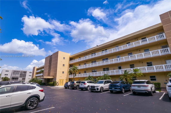 Parking area in front of a multi-story residential building.