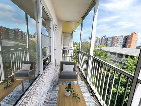 View from a balcony overlooking other buildings and greenery.