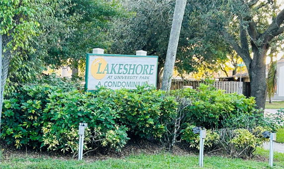Sign for Lakeshore at University Park condominium surrounded by greenery.