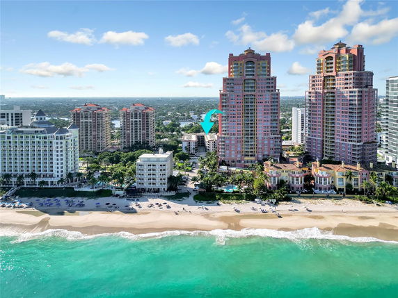Aerial view of beachfront high-rise buildings along a sandy coastline.