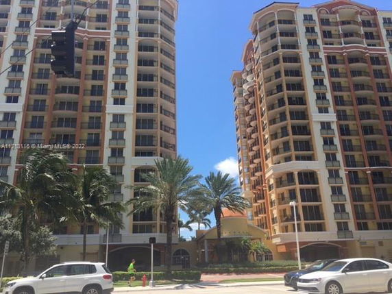 Front view of two adjacent multi-story residential buildings with balconies.