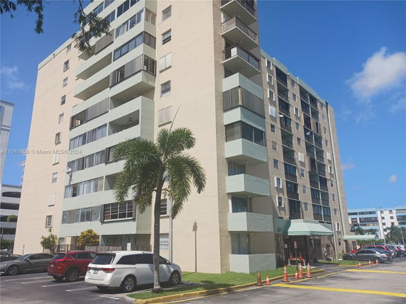 Front view of a multi-story apartment building with balconies.