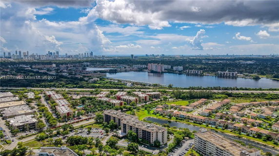 Aerial view of residential buildings near a body of water with a city skyline in the background.