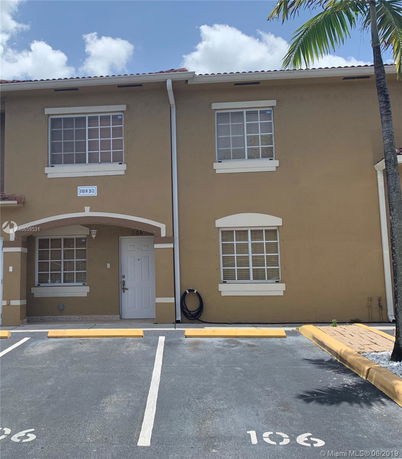 Front view of a two-story building with designated parking space.