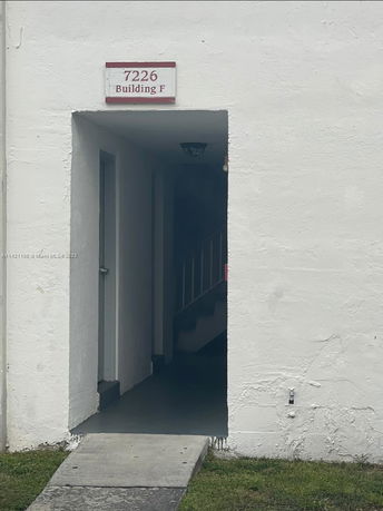 Entrance view of Building F with a visible doorway and stairs.