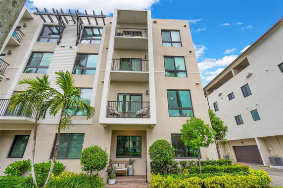 Front view of a multi-story apartment building with balconies.
