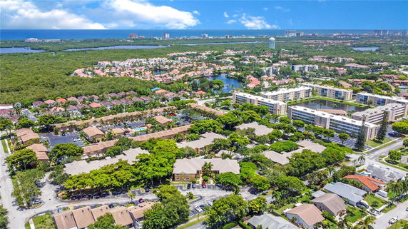 Panoramic aerial view of a residential area with multiple buildings and green spaces.