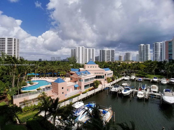 Panoramic view of a marina with buildings and swimming pool.