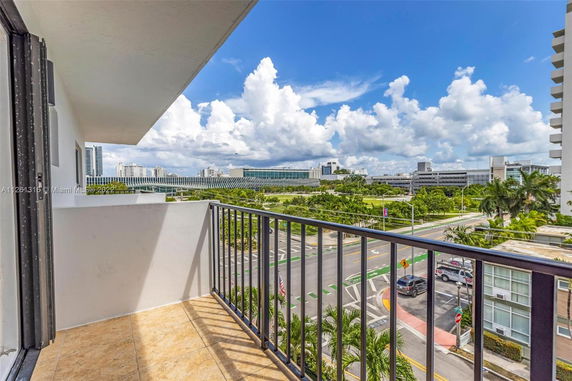 View from a balcony overlooking urban surroundings with roads and buildings.