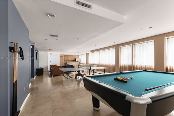 Interior view of a recreational room with a pool table and table tennis setup.