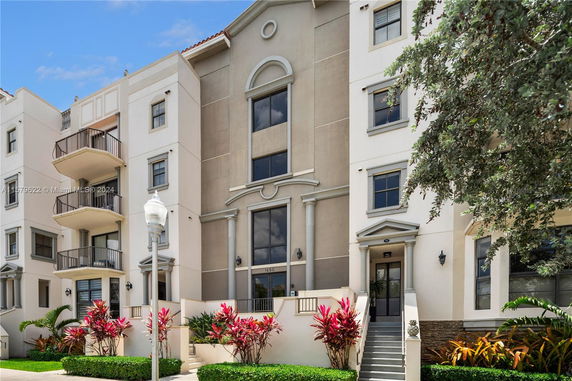 Front view of a multi-story building with balconies and decorative columns.