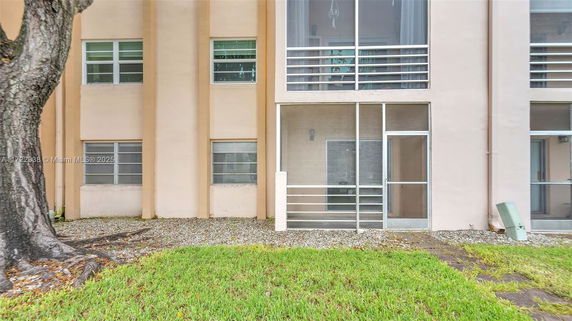 Front view of a building with a screened patio and multiple windows.