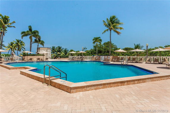 Outdoor swimming pool area with lounge chairs and umbrellas.
