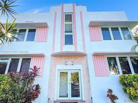Front view of a two-story building with pink and white accents.