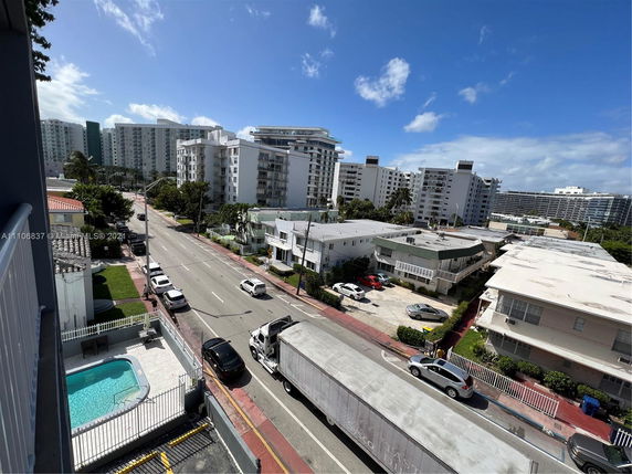 Panoramic view of a street with multiple residential buildings and a small swimming pool.