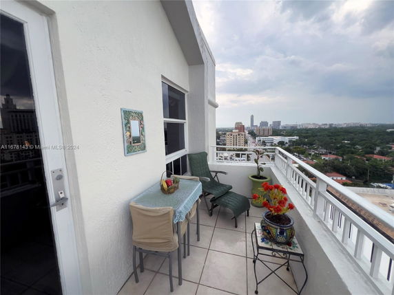 Outdoor balcony with seating and cityscape view.