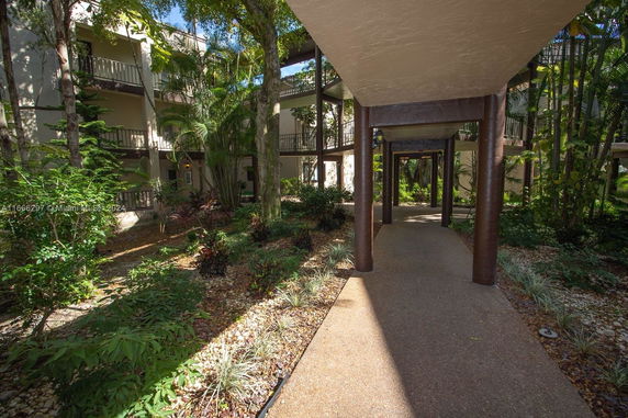 Outdoor pathway surrounded by greenery and residential buildings.