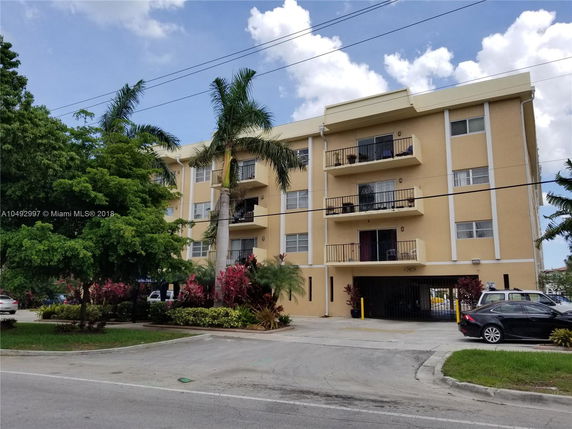 Front view of a four-story apartment building with balconies.