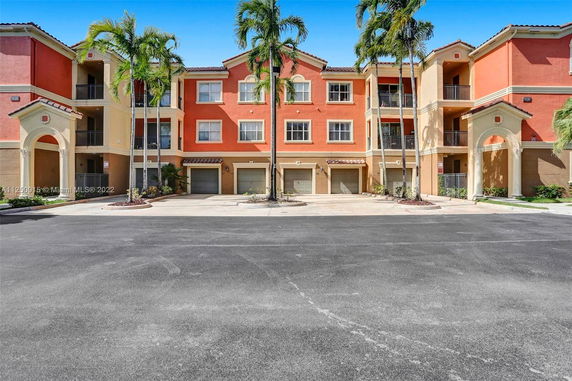 Front view of a three-story apartment building with garages.