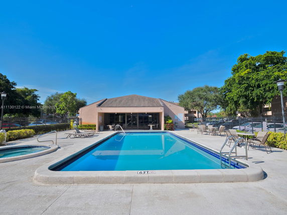 Outdoor swimming pool with surrounding deck area and lounge chairs.