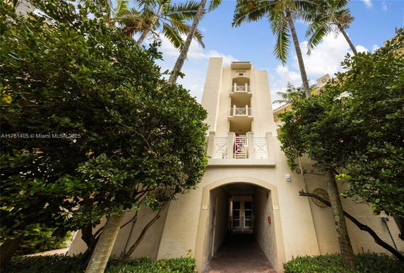 Front view of a multi-story building with balconies and an archway entrance.