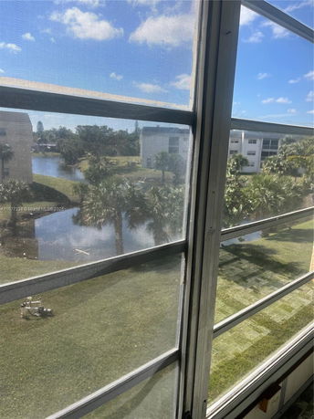 View of surrounding buildings and a body of water seen through a window.
