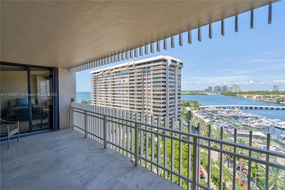 Balcony view with railings overlooking buildings, marina, and water.