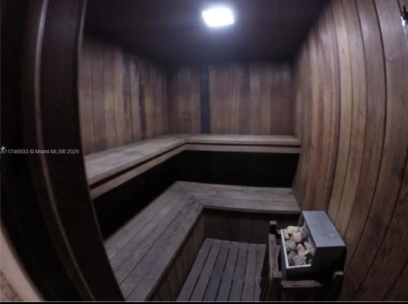 Interior view of a wooden sauna room with benches and a sauna heater.