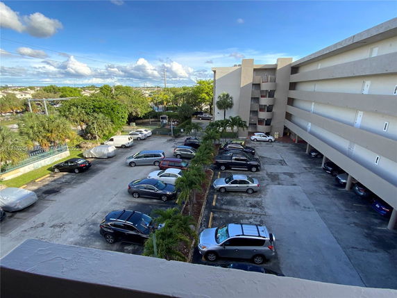 View of an outdoor parking area adjacent to a multi-story building.
