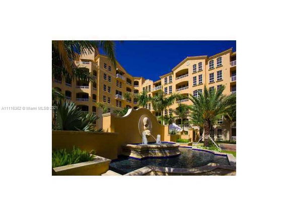 Front view of a multi-story apartment building with a decorative fountain.