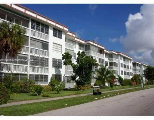 Front view of a multi-story apartment building with balconies.