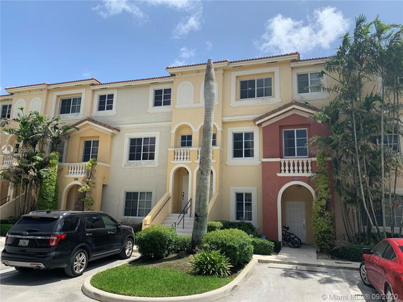 Front view of a three-story residential building with multiple entrances.