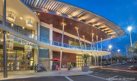 Front view of a multi-level commercial building with a modern design and large entrance.
