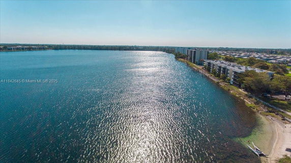 Aerial panoramic view of a coastal area with buildings along the shoreline.