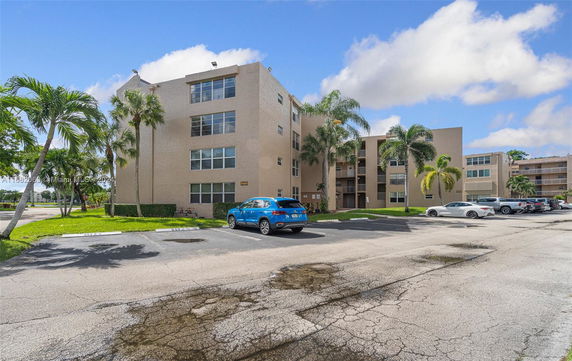 Outdoor parking area in front of a multi-story residential building.